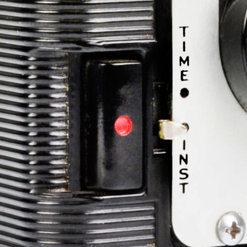 Black button, red dot, switch to right labeled 'Time' above and 'Inst' below